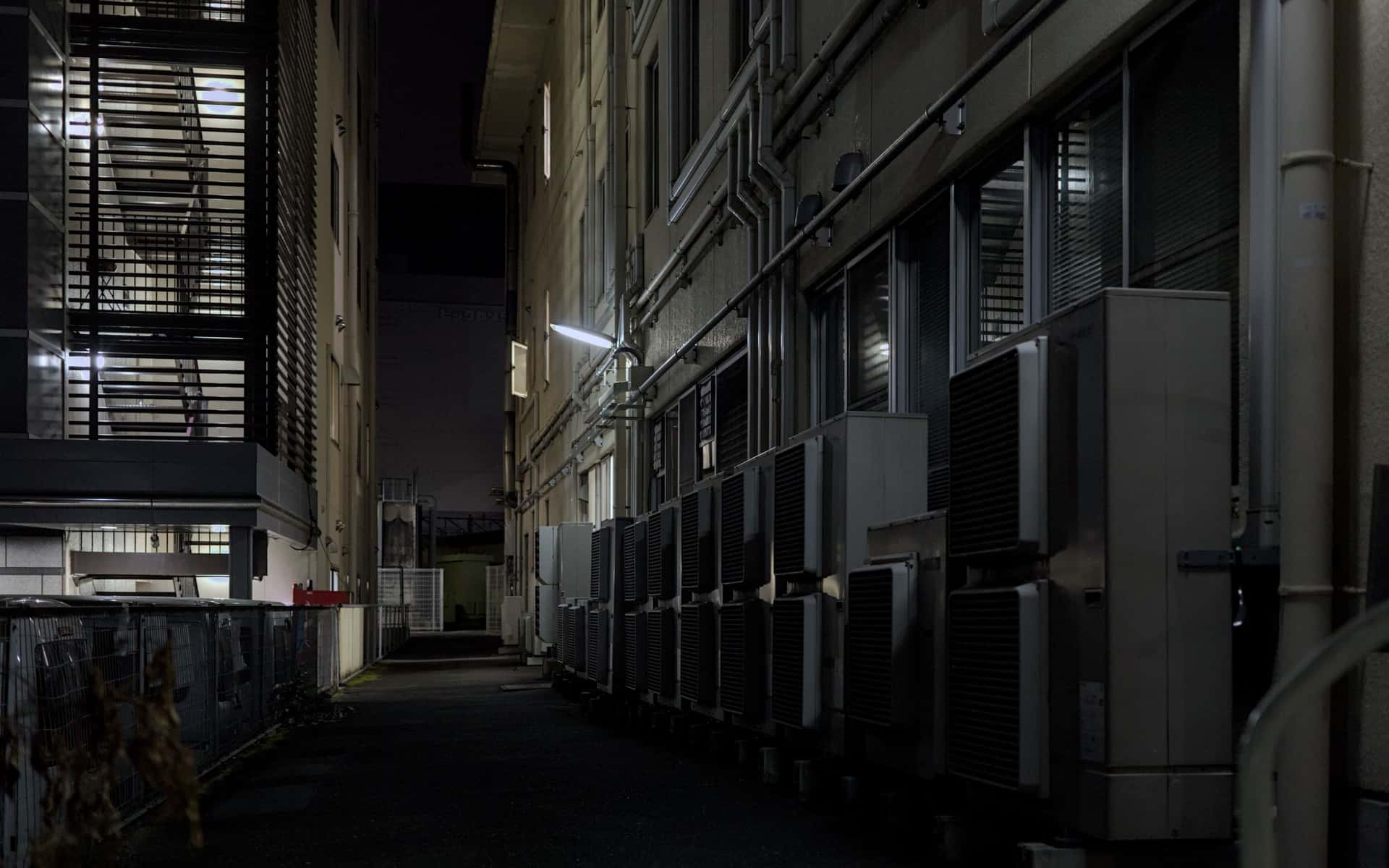 An outdoor air conditioning condenser unit against a wall