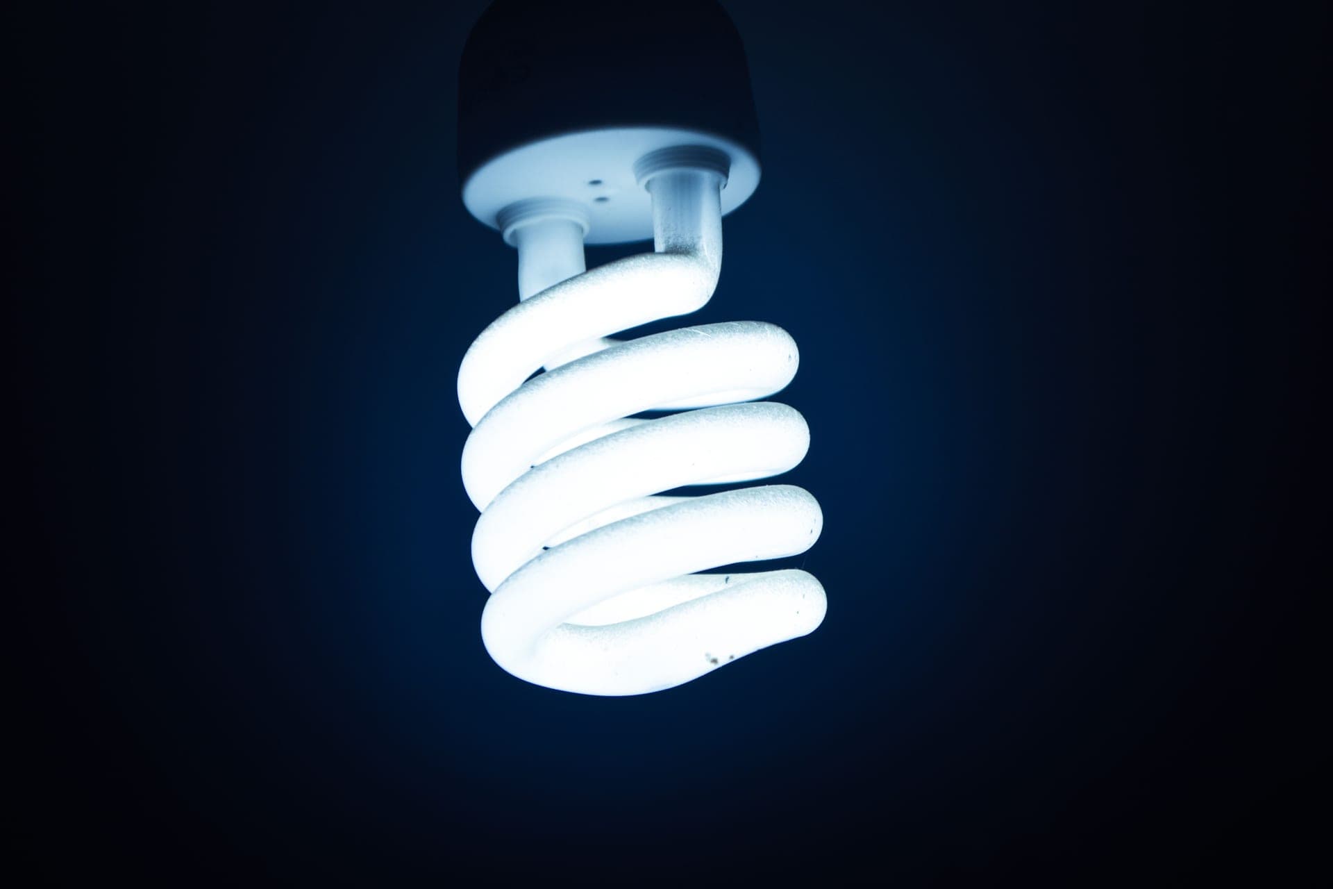 A bare filament bulb against a dark background