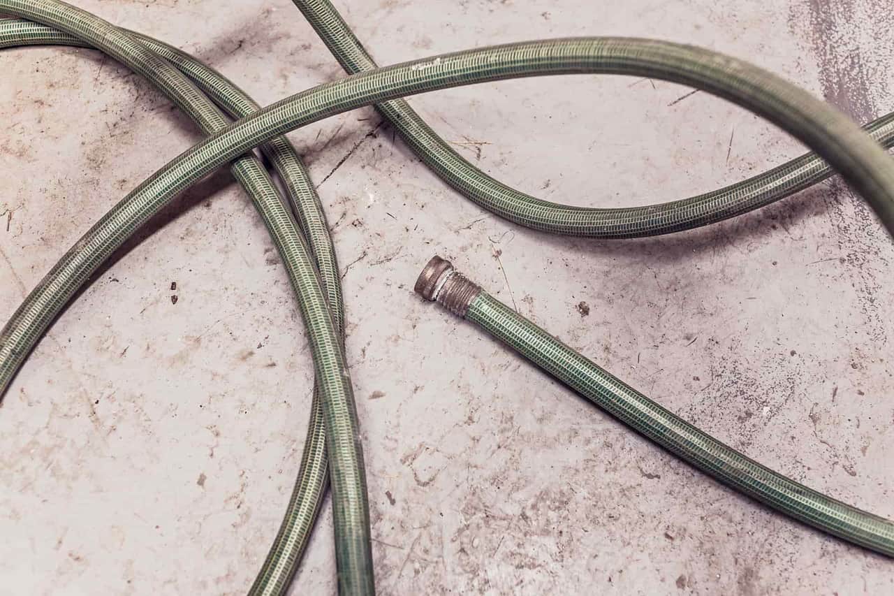 A garden hose coiled on a concrete floor