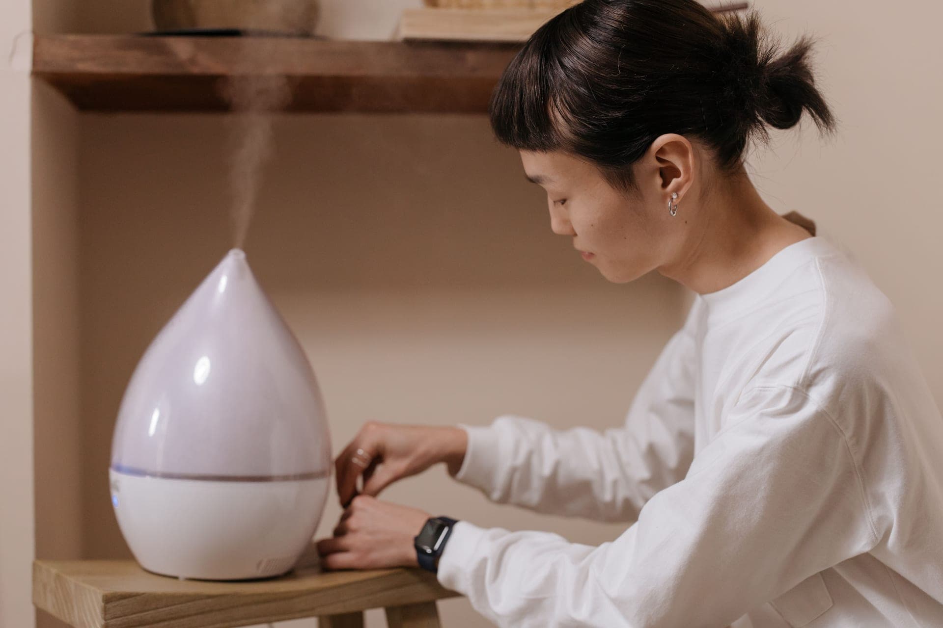 Fine mist rising from a humidifier against a dark background