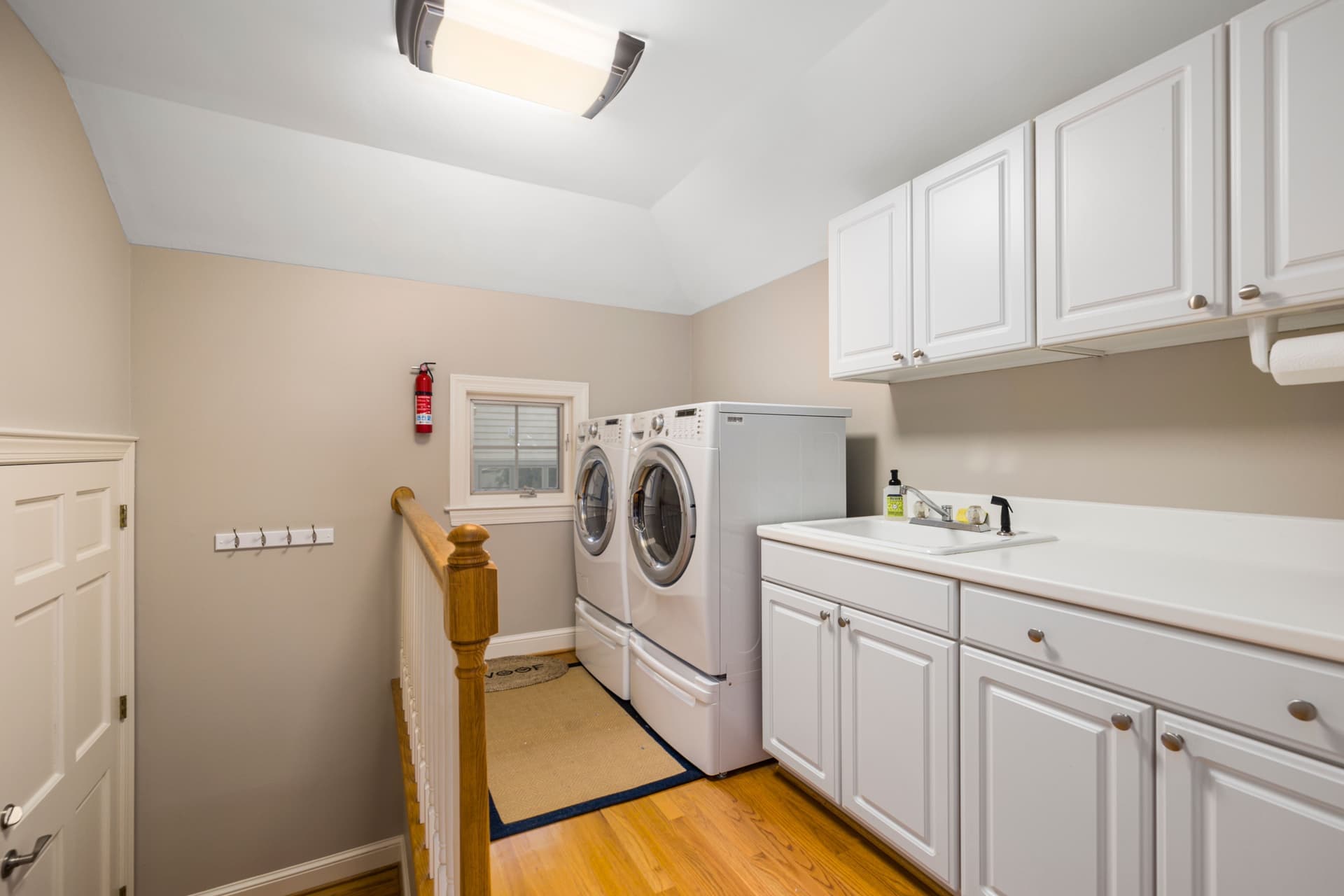 A laundry room utility sink with exposed plumbing