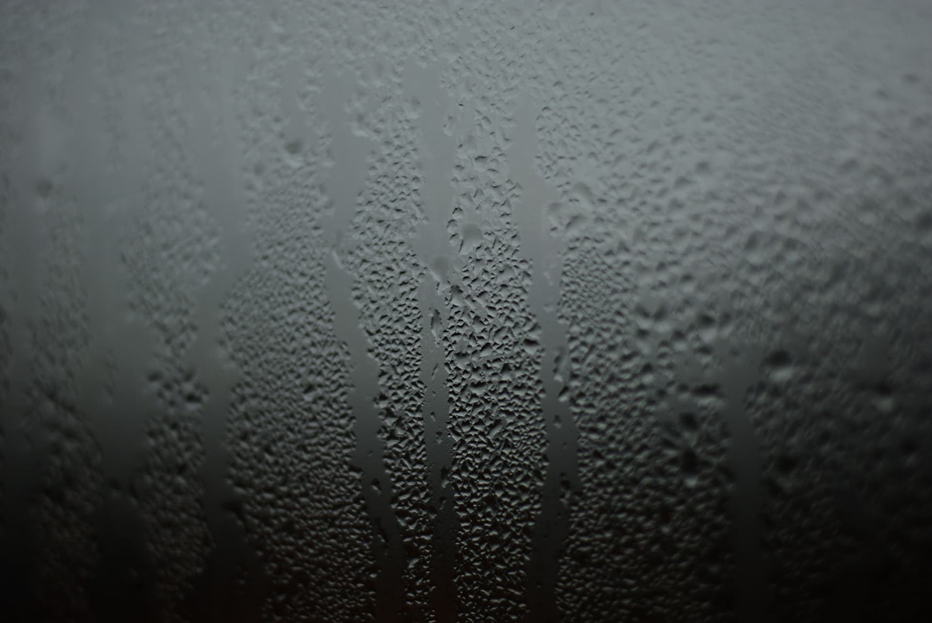 Heavy condensation beaded on the inside of a cold window pane